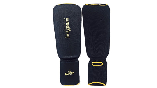 Pair of black shin guards with yellow accents on a white background A pair of black and yellow shin guards with hook-and-loop straps a product of https://www.shopwarriorstyle.com/