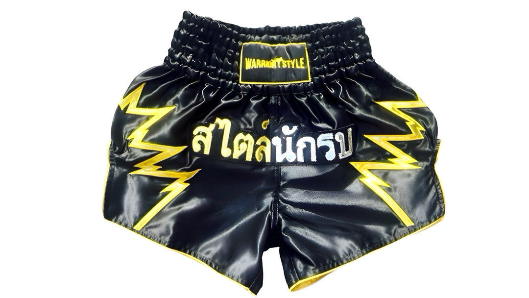 Muay Thai Shorts Black Muay Thai shorts with yellow lightning designs and text on a white background a product of https://www.shopwarriorstyle.com/
