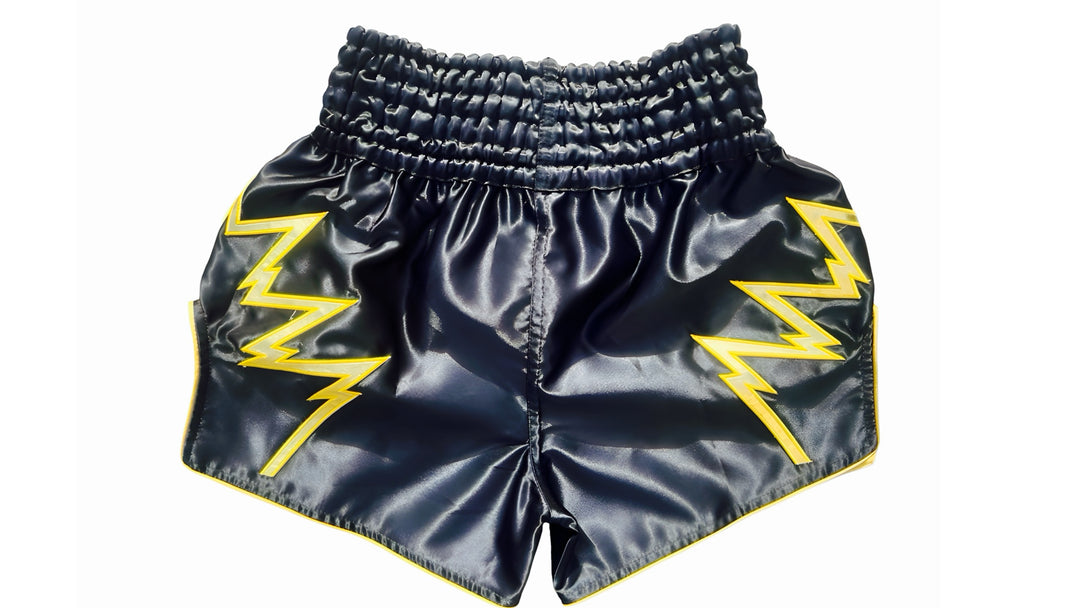Muay Thai Shorts Black shorts with yellow lightning bolt designs on a white background Black Muay Thai shorts with yellow lightning designs and text on a white background a product of https://www.shopwarriorstyle.com/
