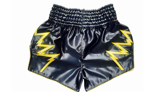 Muay Thai Shorts Black shorts with yellow lightning bolt designs on a white background Black Muay Thai shorts with yellow lightning designs and text on a white background a product of https://www.shopwarriorstyle.com/
