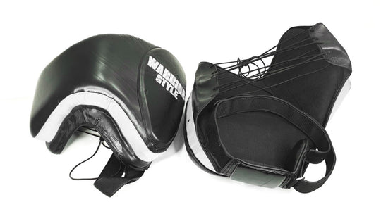 Thigh Pads muay thai elbow pads kick pads karate thai shin pads kick pads wrestling A pair of black leather thigh pads with white accents, featuring foam padding and a locking nylon waist strap a product of https://www.shopwarriorstyle.com/